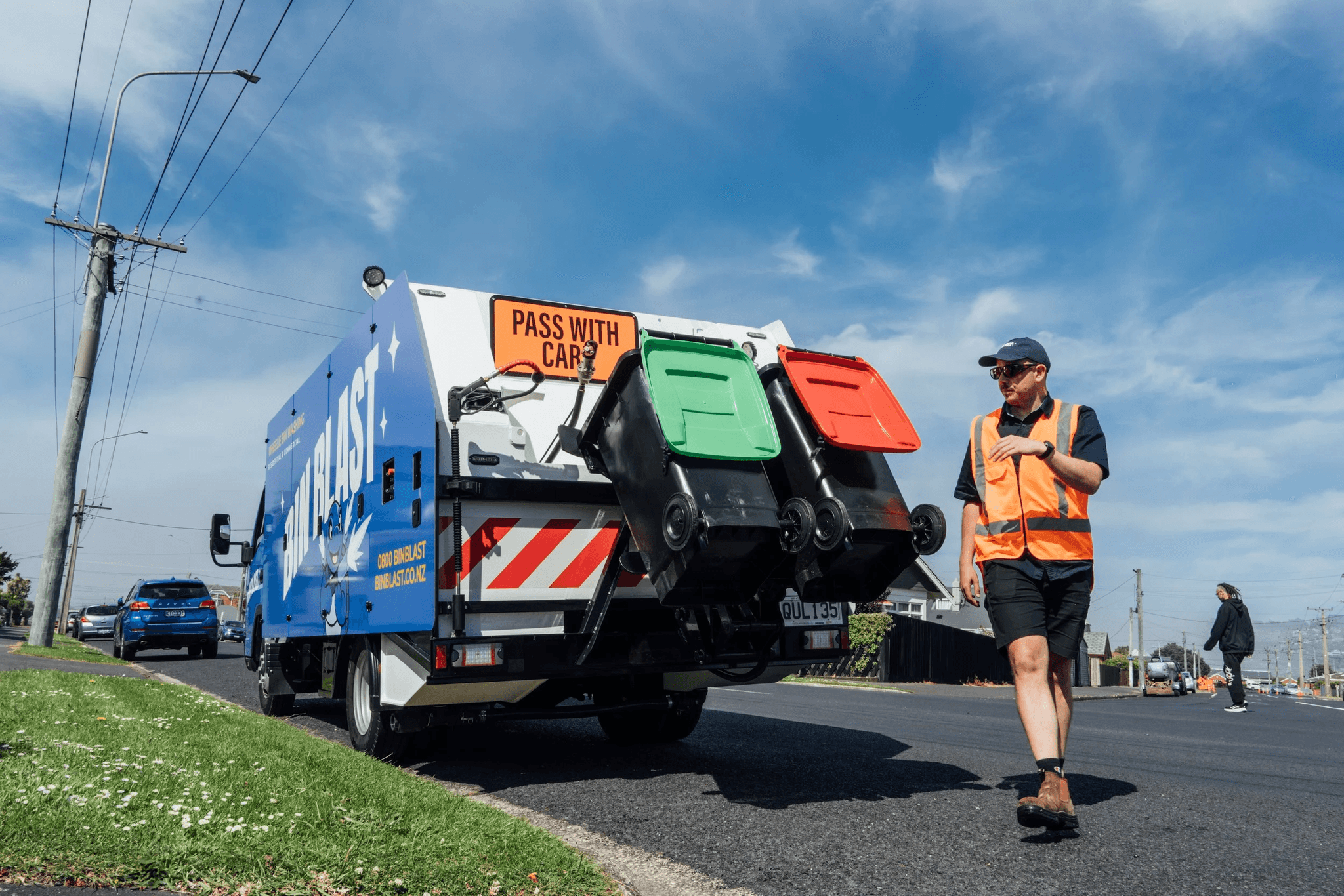 Bin Blast worker walking beside the truck on a Dunedin street