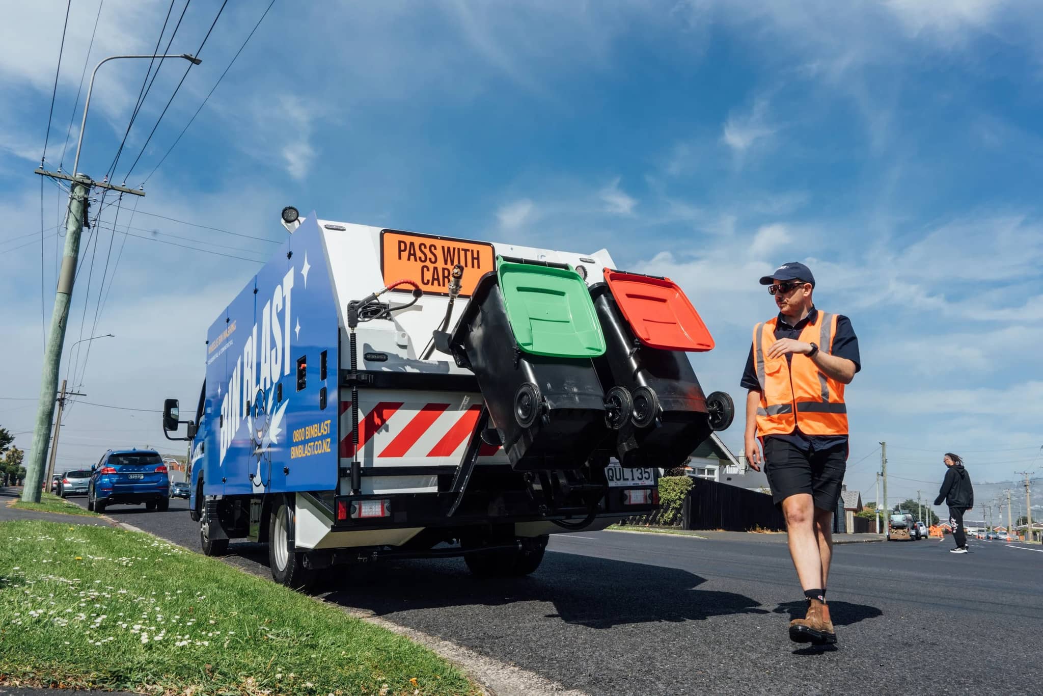 Bin Blast worker walking beside the truck on a Dunedin street